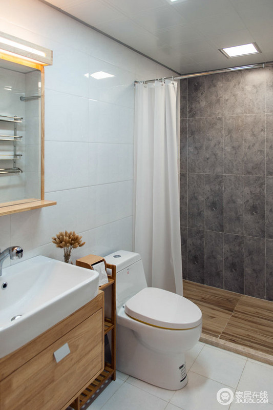 日式浴室以实用为主，白色瓷砖与灰色墙砖构成色彩层次，木地板搭配木框镜子，并与白色陶瓷台盆形成组合，利落而整洁。
