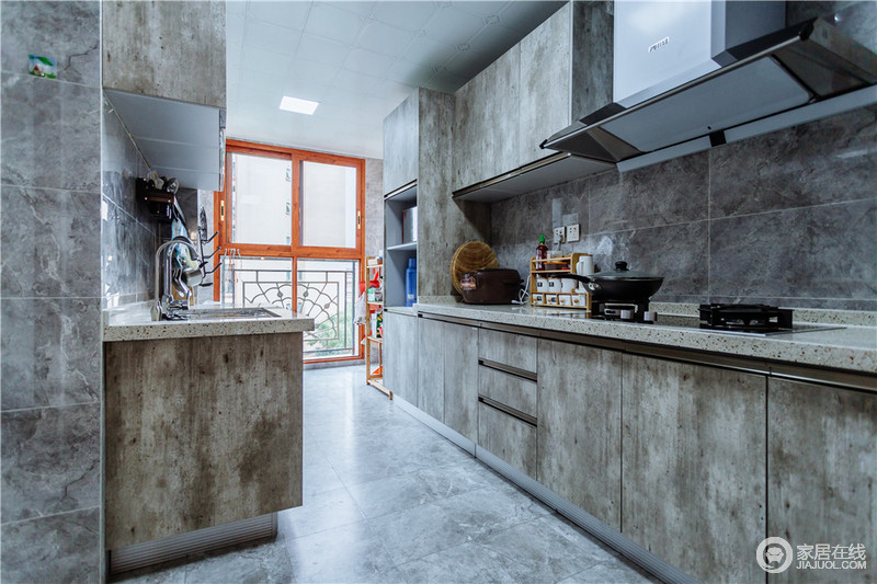厨房的采光充足，所以即使空间的原木橱柜颇显老旧斑驳，但是与水泥灰的地砖搭配出实用而利落的设计。