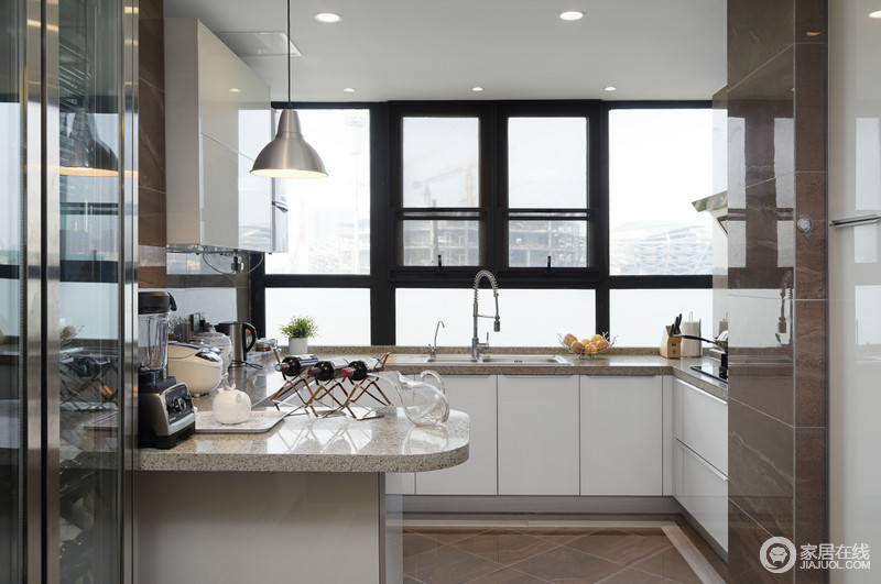 回字形厨房以吧台简单强调功能性，并与一旁的酒柜营造休闲自在的生活方式；白色橱柜面整洁白净，与黑色金属窗户呈对比冲撞，却让厨房实用中蕴藏着现代美学。