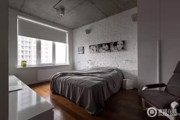 卧室区域则显得简洁，灰色的天花板，裸露电线的灯具，粉刷成白色的砖墙