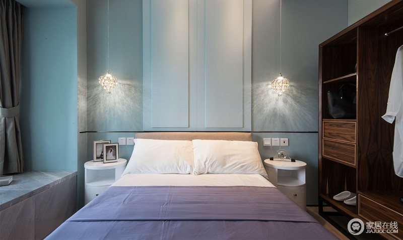 卧室以蓝色的立面来张扬清逸，现代设计感强烈的白色圆柜对称而放，中和出宛如天空般的视觉美感；褐色衣柜兼容华贵典雅与时尚现代，虽然简化了线条，但是依靠材质的魅力，赋予空间传统底蕴。