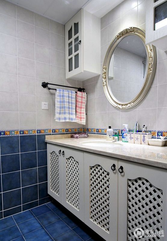 卫浴间以蓝、灰白色砖石来铺贴出地中海般的清惬，面积不大却让人倍感舒适；白色盥洗柜拱形镂空立面也迎合着主题，颇具特色。
