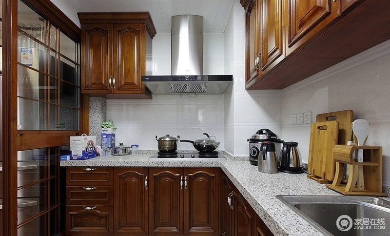 厨房色调与整体设计相统一，采用实木打造橱柜，厚实中更显出质感。