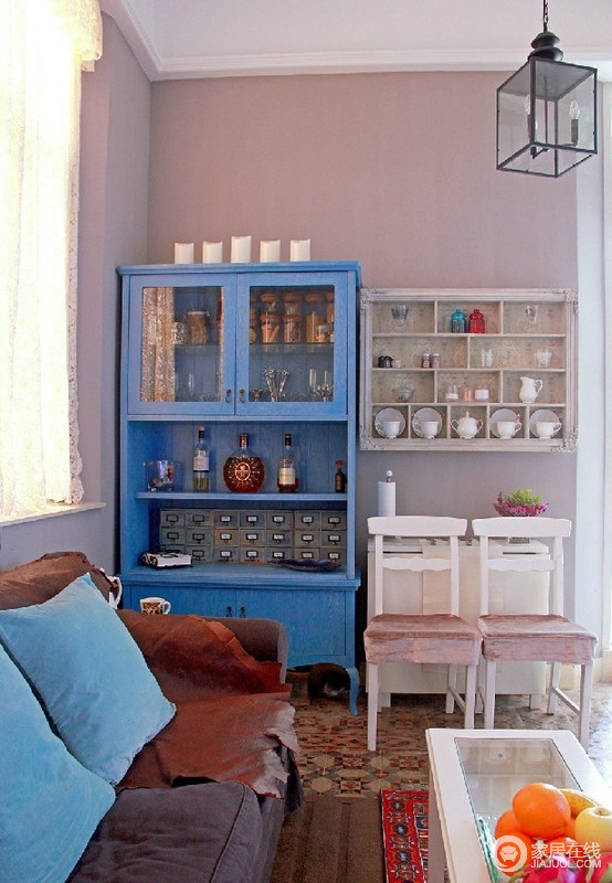 小小的客厅合理利用空间就尤为重要，蓝色酒柜与悬挂架将家居用品收纳其中，陈列出温馨的味道，折叠式餐桌方便实用，为生活添彩不少。