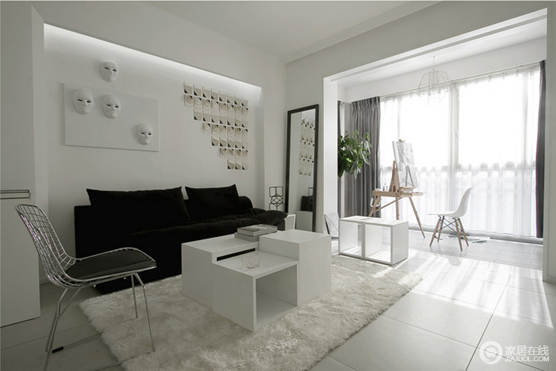 客厅以白色为主，通过黑色布艺沙发来构建空间的色彩层次；不论是茶几还是收纳柜都以白色为主，与白色地毯呈一片雪景，简单的形式让生活愈加舒适。