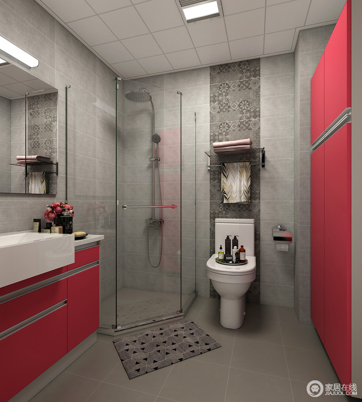 卫生间以深灰色砖石来铺贴墙面和地面，马桶的立面以马赛克砖铺贴出一种立面的层次；角落的淋浴间解决了干湿的问题，而红色储物柜和盥洗柜实现了收纳，同时为空间带来一抹红的摩登。
