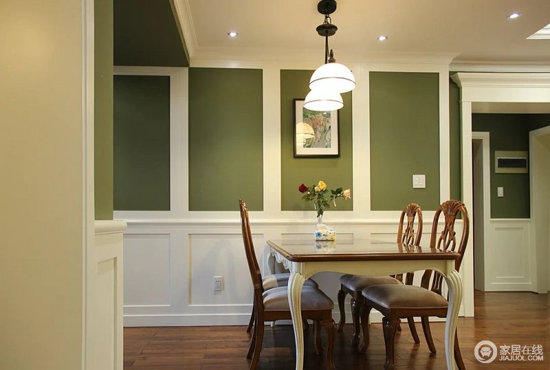 餐厅背景墙和客厅同一使用白色护墙板，上半部分用绿色乳胶漆饰面.