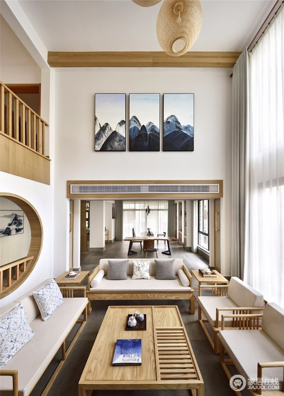 双层挑高的客厅，与二层的主过道相同，不仅增强了空间感，以中式建筑结构演绎空间的方圆和谐；写意画与客厅内的实木新中式家具组合，赋予空间雅致和温馨。