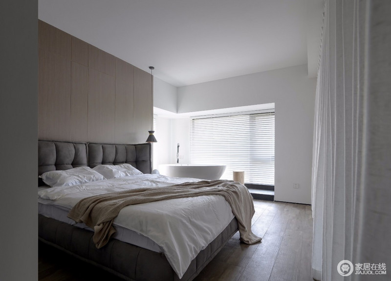 整个卧室我们所要营造的感觉就是舒适，将近2米宽的大床显然是这个空间的中心，床头的饰面板质感相对比较硬，与原木地板构成简单的层次之分，而白墙、浴缸和床品带来纯净感，俞显简单、温馨。