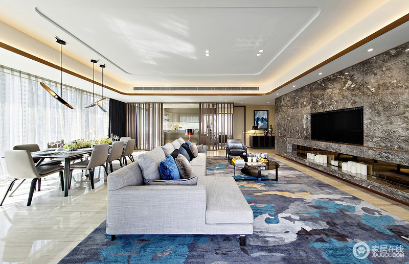 客厅的装修，大理石的电视背景墙，让空间看起来恢弘大气，不一的沙发，蓝灰相间的地毯使空间不过于冰冷