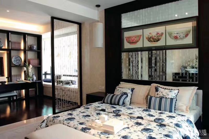 卧室温馨舒适，青色印花床品搭配背景墙中的碗式贴纸突出了中式传统的生活气息；玻璃中式格栅巧妙区分了卧室和书房，给空间带来一种舒适和温馨。