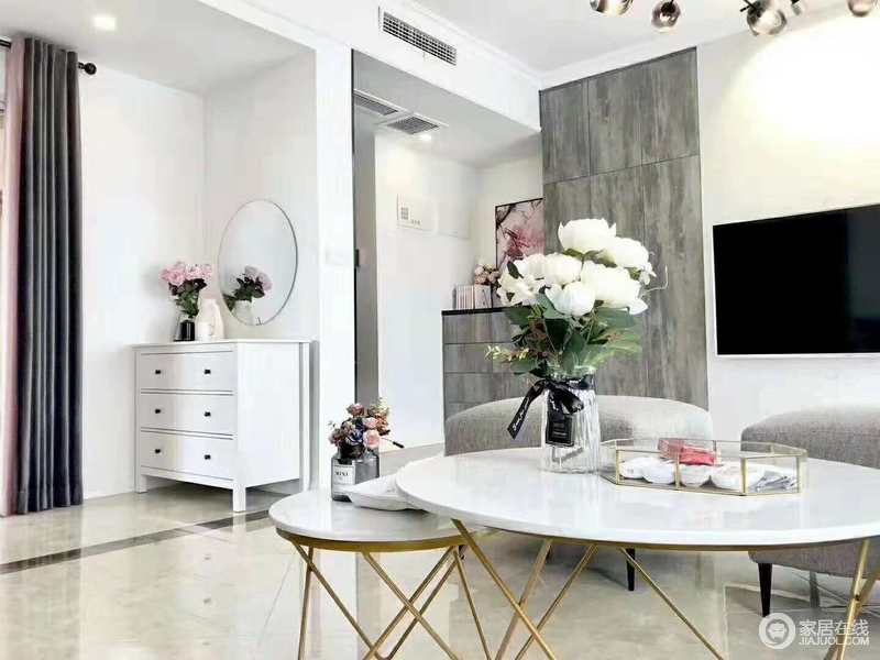 客厅线条简单，以灰色板材来构建空间层次，白色圆几搭配灰色沙发更是让空间多了素雅；转角处的白色收纳柜、圆镜将方圆感融入空间，让空间更为和谐。