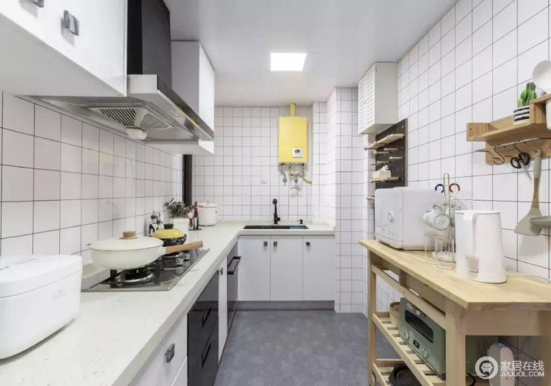 进门的右手边就是厨房了。厨房是狭长型的格局，所以橱柜采用L型的，这样一来动线会更加的流畅。