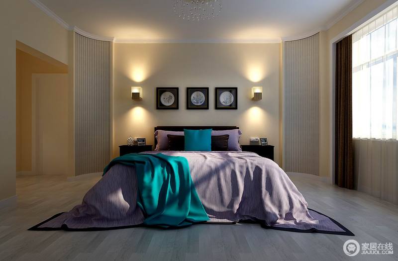 卧室床头的造型比较圆润，床头两侧的拐角饰以条木以弧形演绎，静谧的壁灯灯光打在米黄色的墙壁上，散发出温和的光芒。紫色的床品上，日光洒进来蓝色更显深邃高雅。