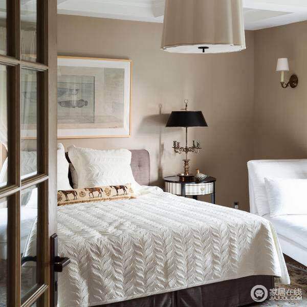 卧室以米白色为基调，在床头柜表面略带雕花，金属台灯，装饰画的装饰下，空间显得优雅矜贵。