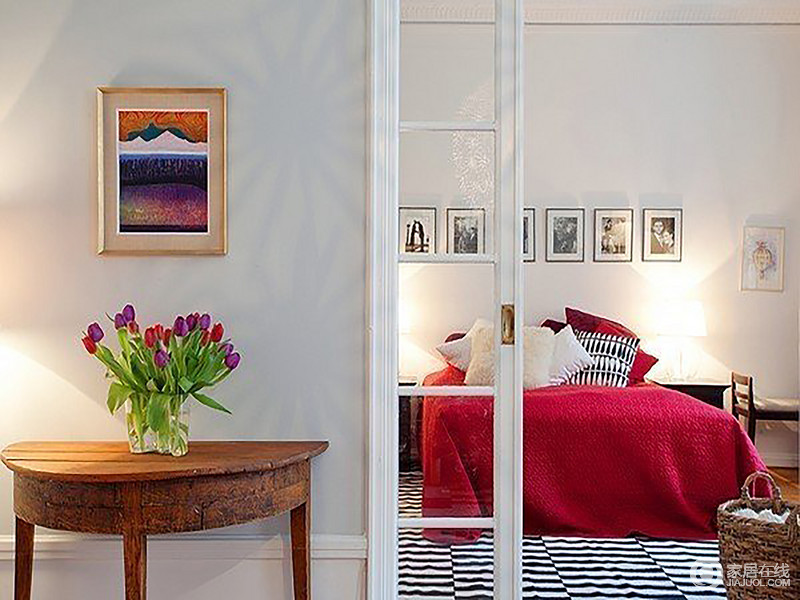 卧室主打白色，粉红色床品、黑白条纹地毯、黑白框装饰画，让简单的空间无处不带着一股时尚的气息；强烈的对比加深了空间的质感和层次，门外的实木桌、简画与花器渲染出柔情蜜意和温情惬意。