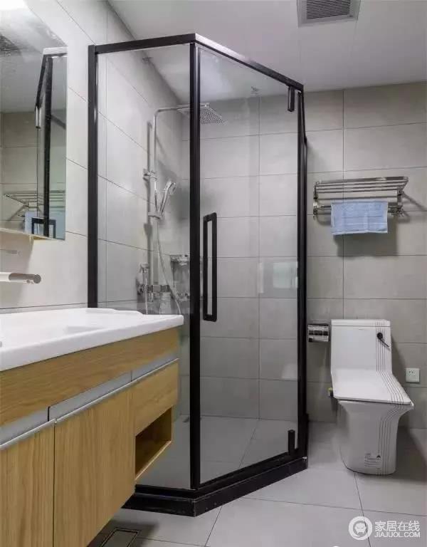 卫生间内部做了干湿分离的设计，利用转角空间来布置一个钻石形的淋浴房，通体灰色的设计搭配木质和白色的卫具，显得更为简约自然。