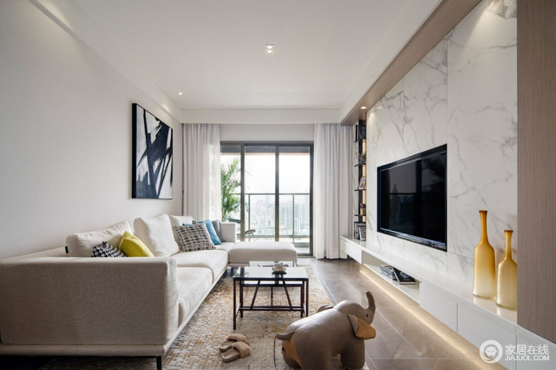 整体客厅空间面积相对紧凑，在现代舒适的风格与格局布置下将电视嵌入理石背景墙，形成黑白格调；白色的沙发搭配黑色抽象挂画、方形茶几和彩色靠垫，素静简约却足够时尚。
