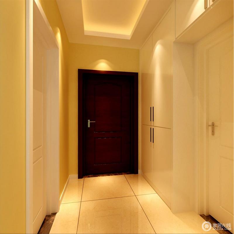 入户走廊上，设计师将玄关柜内嵌入墙，使空间规整利落的突显出简洁感；鹅黄色的墙面与白色的房间门及壁面柜，在点光源的布光下，盈满轻盈温馨的舒适惬意；红木大门，则鲜明的展现出视觉层次。