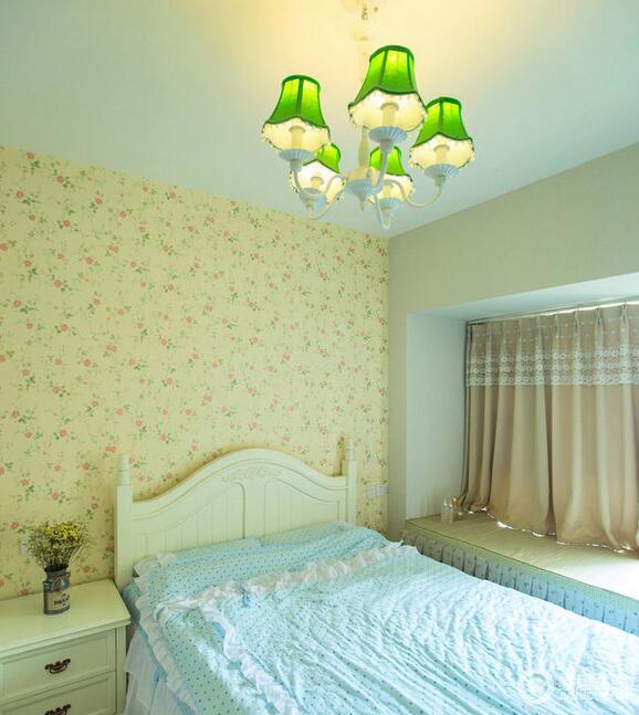 主卧室同样选择了田园格调的碎花墙纸搭配奶白色的公主床，翠绿的琉璃吊灯让空间变得清新脱俗又不失“乖乖女”的俏皮可爱