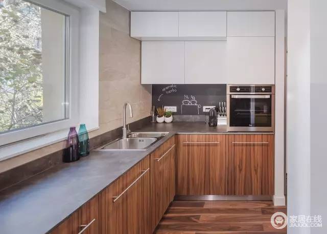 厨房采用原木色线条感强烈的柜体，白色的柜子，灰色的台面，显得宽敞。