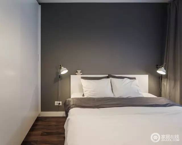卧室的背景墙是用灰色的墙纸，两侧是白色的墙和衣柜，现代风格的壁灯。