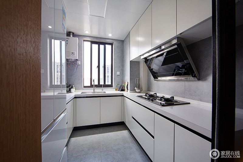 厨房采用U型设计，以白色的整体橱柜与灰色的理石背景墙和地面搭配，色彩相近，显得简洁硬朗；窗户带来充足的自然光线，加上灰白色彩的营造，空间质感通透明快。