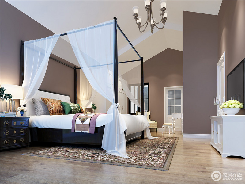内敛沉和的灰紫色墙面与白色人字天花顶，拉伸了空间的视觉高度，大而开阔的卧室里，四柱床上的纱帘，增强了空间的私密感，敦厚的床头柜与繁复的印花毯，带来质朴自然。