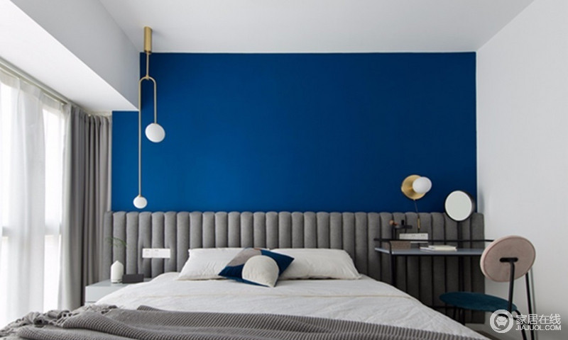 卧室以蓝白色为主，奠定了干净、清新的氛围，不对称式的床头灯设计，让原本有序的软包床头多了一些调皮，也彰显了工业时尚。
