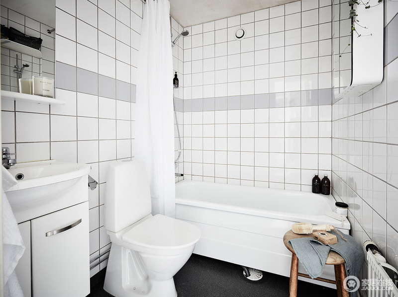 白色设施、浴帘和橱柜提供足够的空间,一个简单的木制凳子和两个镜子