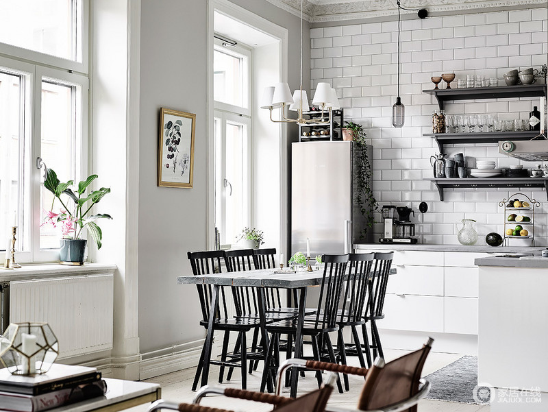高,黑色的木椅子上坐着一个灰色的板条的表,而白色橱柜在厨房中引人注目的灰色。