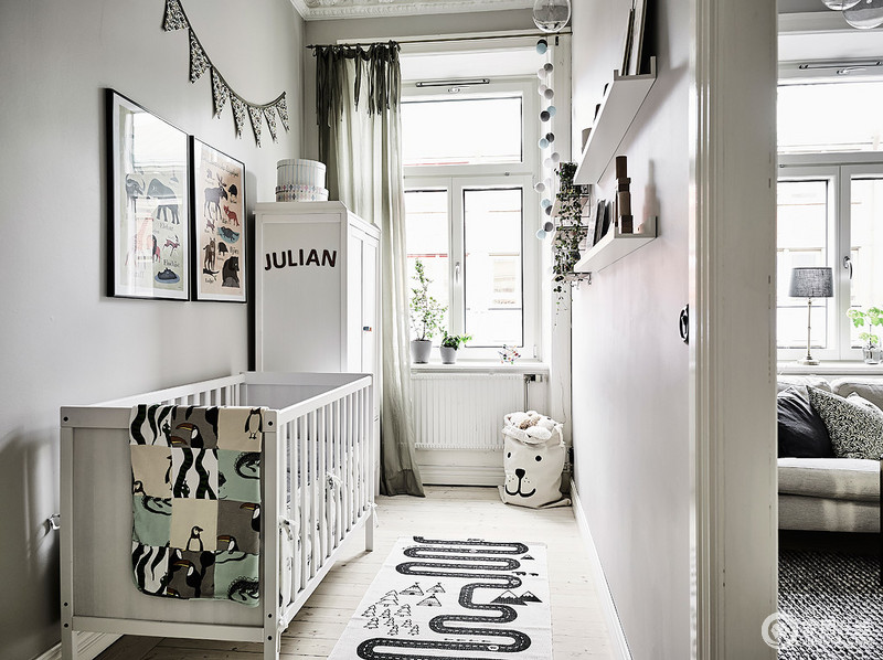 走廊空间是由明亮的灰色油漆和白色细木工,与白色的小墙书架和一个匹配的床。