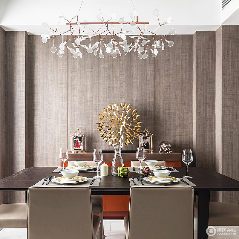餐厅采用和客厅颜色统一的木色，力求雅致精炼，营造简单朴质，但是金属的装饰与树叶状的金属吊灯反衬着艺术反衬出的大气非凡。