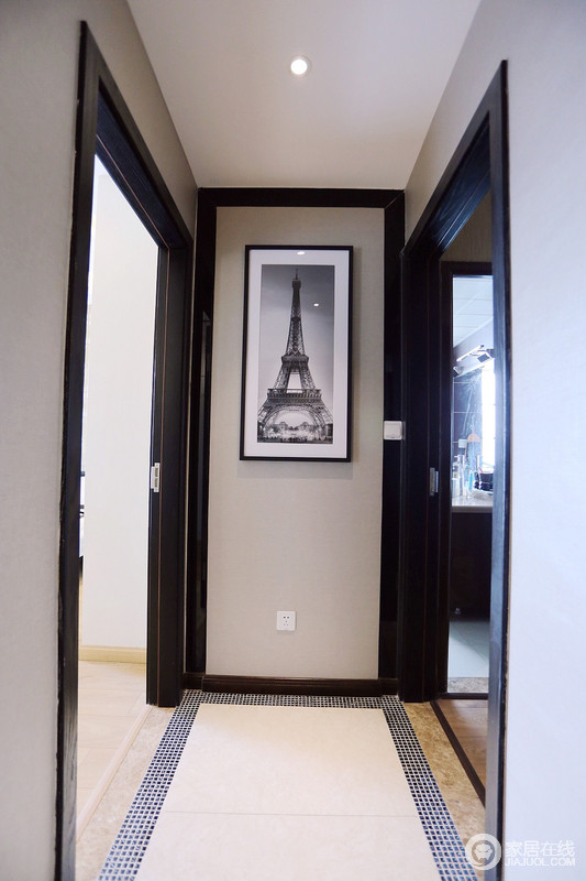 走廊连接着各个空间，设计师用灰色的墙面搭配黑色的门框，雅致且沉稳；端景墙上的挂画，装饰出几分艺术气息。