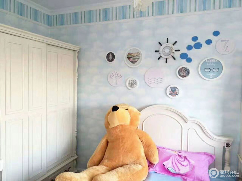 卧室浅蓝色的壁纸，营造一种清新的小格调，搭配白色家具，构成空间的轻快；粉色床品更为甜美，与造型各异的墙饰，让空间充满活力。