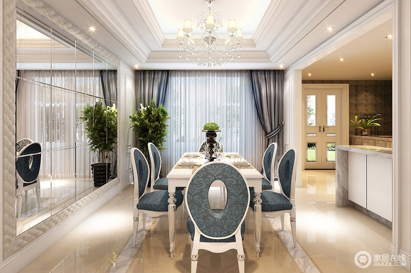 餐椅与开放式厨房相对，设计师利用一整面墙面装饰镜折射空间，增加室内开阔和明快感。墨蓝色椅面的餐椅优雅端庄，在白色的搭配下，显得精致质感。