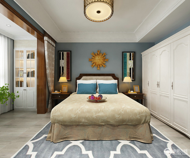 卧室线条简洁，利用吊顶和门框将休息区与阳台区分隔，既规整又功能明确；蓝色漆粉刷的背景墙因为彩色挂画和木质饰品多了艺术生动，美式褐色实木螺纹床头柜和白色衣柜对比中凸显出现代美式的雅致，蓝色地毯和驼色床品带着温馨、舒适，与阳台处的书柜让你尽享生活的惬意。