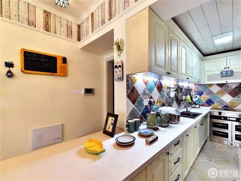 厨房以米白色的橱柜来搭配白色水磨石台面，浅色上的变化，给予空间一种干净；而彩色菱形砖的铺贴给予空间几何与色彩上的新颖，让烹饪时光也变得更为美好起来。