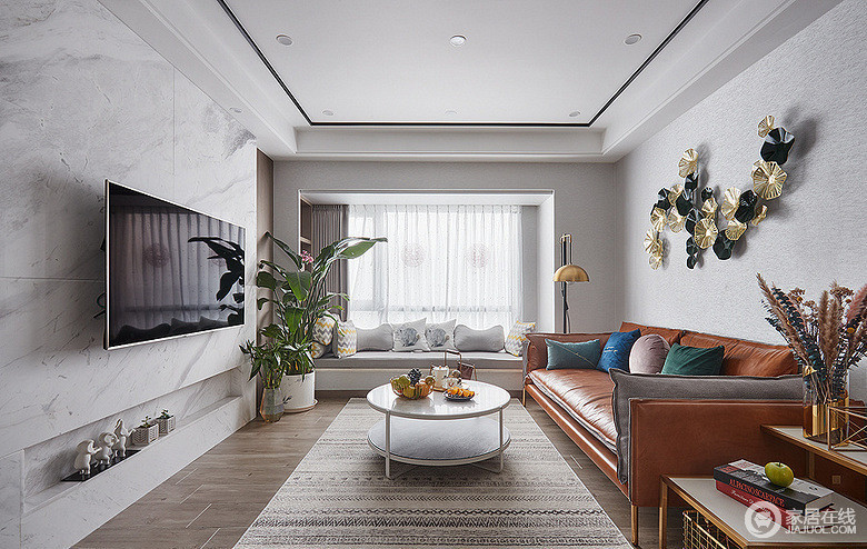 客厅采用一贯的灰白色调，显得简洁硬朗；而松软皮质的棕色沙发和点缀的多彩靠包，则瞬间让空间温暖起来，同时也与金属材质的几类和配饰，让空间有了时尚调性。