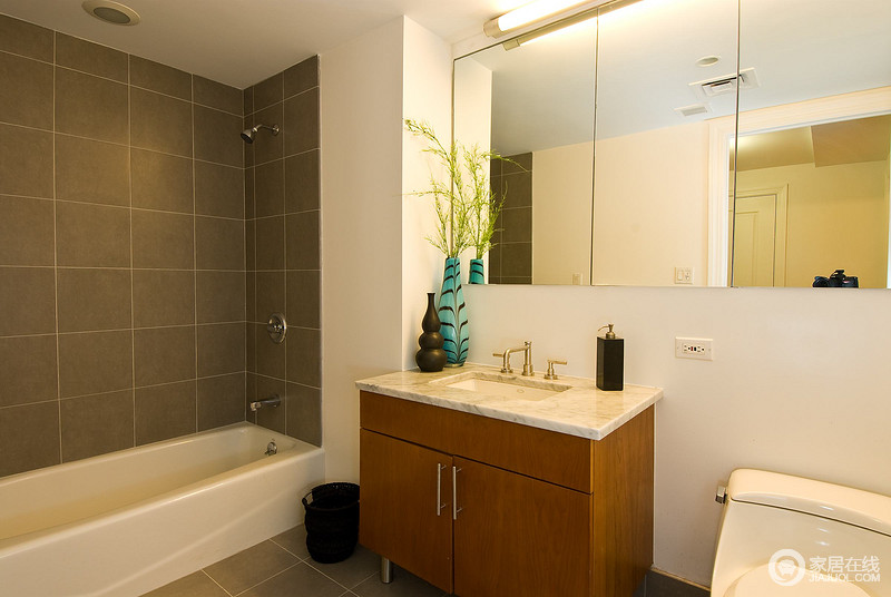 卫浴间设计得十分简单，主要以实用性出发，木质盥洗柜上的蓝色、褐色花瓶无疑是空间的焦点，带来另类的艺术风，改变了略显乏味的空间。