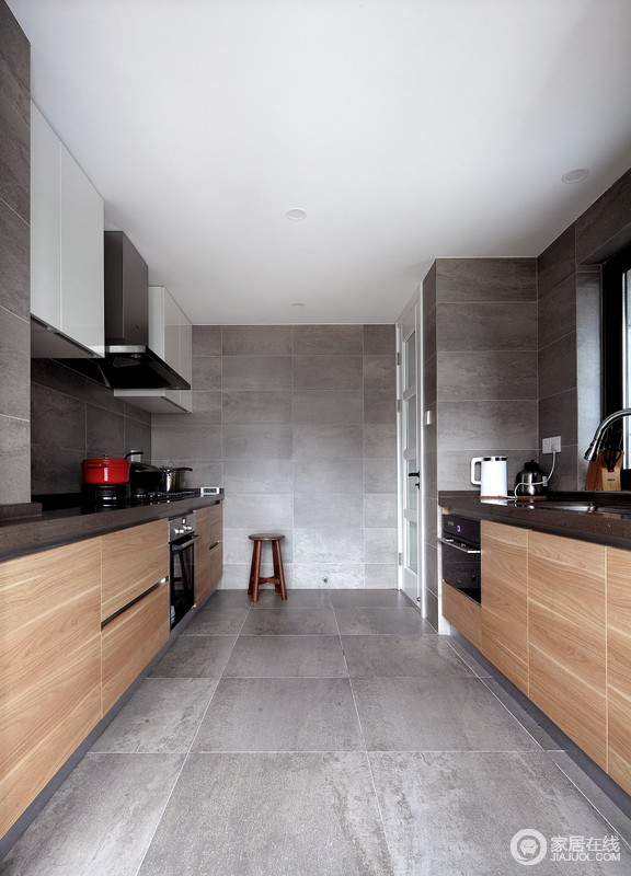 厨房以防水泥砖石铺贴墙面与地面，为空间营造一种高冷；黑白色系的吊柜与原木橱柜以材质与色彩，造就质感空间。
