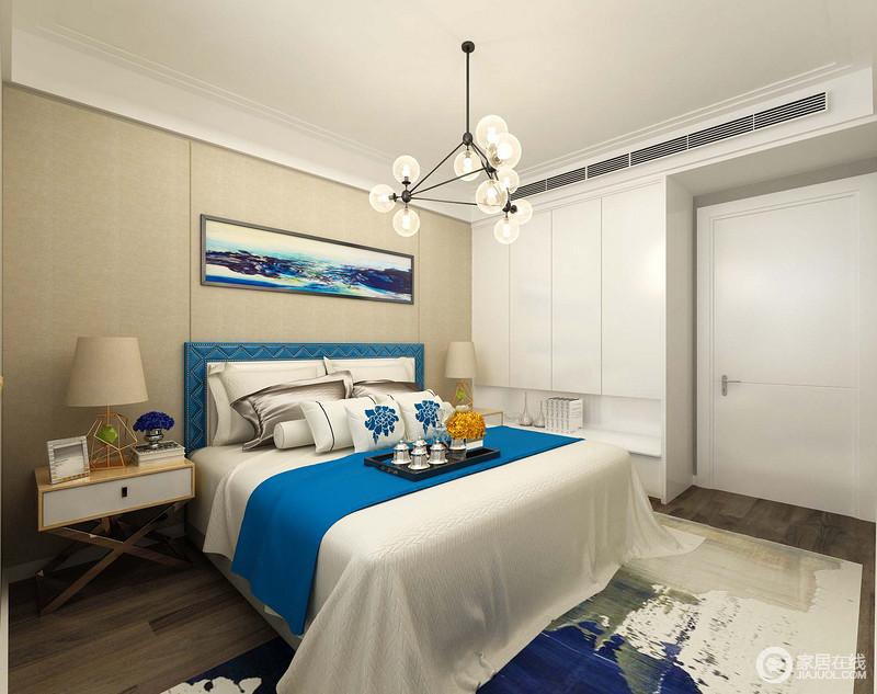 卧室虽然面积不大，但是定制的衣柜巧妙实现了功能性，还不占用太多的空间；米色背景墙上悬挂的画作与床品形成呼应，给家带来蓝色优雅。