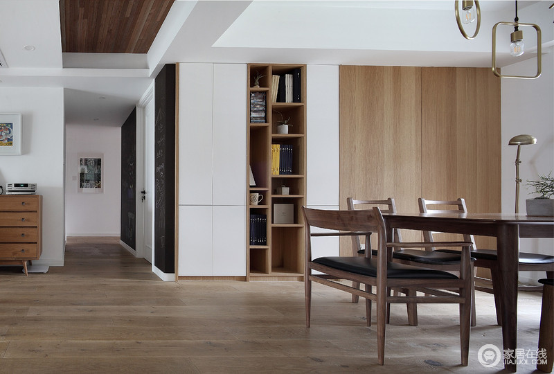 餐厅借原木门将收纳区作美化，刚好与书柜和木立柜构成营造出一种木雕纯净，再加上实木餐桌椅，更奠定了空间的木质朴素格调。