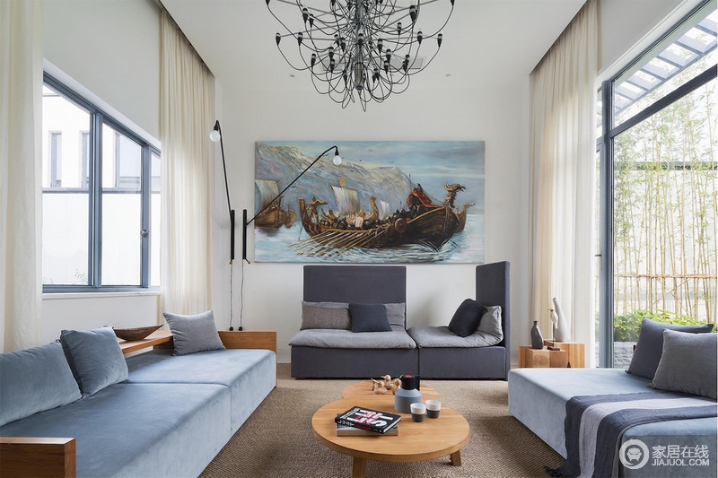 简单的天花与家装配饰相辅相成，和谐有张力；不同色度的灰色与蓝色拼接而组的沙发柔软舒适，让空间温婉大方。