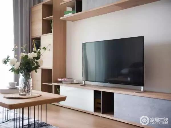 客厅的电视背景墙被利用起来做了收纳，简单的木质柜子和白墙搭配起来，增强客厅的储物能力，在颜值上也不会难看。