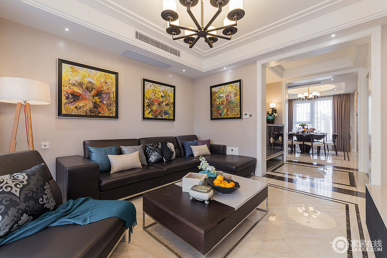 客厅空间的墙面与沙发组及茶几，形成鲜明的黑白对比，加强了空间上的层次营造；布艺和装饰画的色彩及图案，为空间平添了优雅气质。