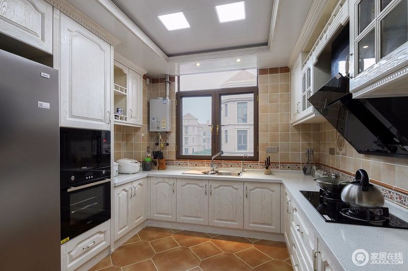 不规则房型的厨房中，以白色橱柜与浅色墙面呈现，由于独特的房型让这间厨房的空间显得略微狭小，但在白色橱柜的衬托下让空间有所扩容，同时具有一定的美观实用性。