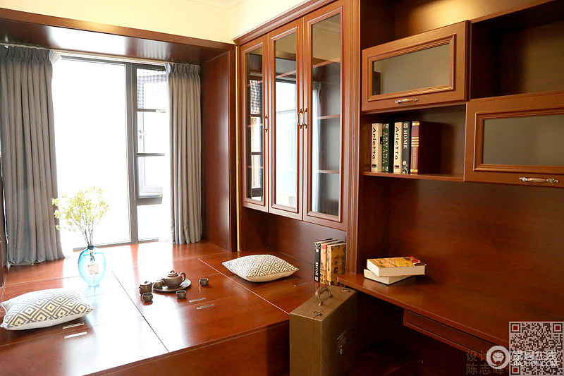 书房其实也是休闲区，沿着飘窗做了榻榻米，榻榻米和橱柜均采用中式风格里常见的棕红色，根据书房的功能特性，整体风格偏向中式混搭