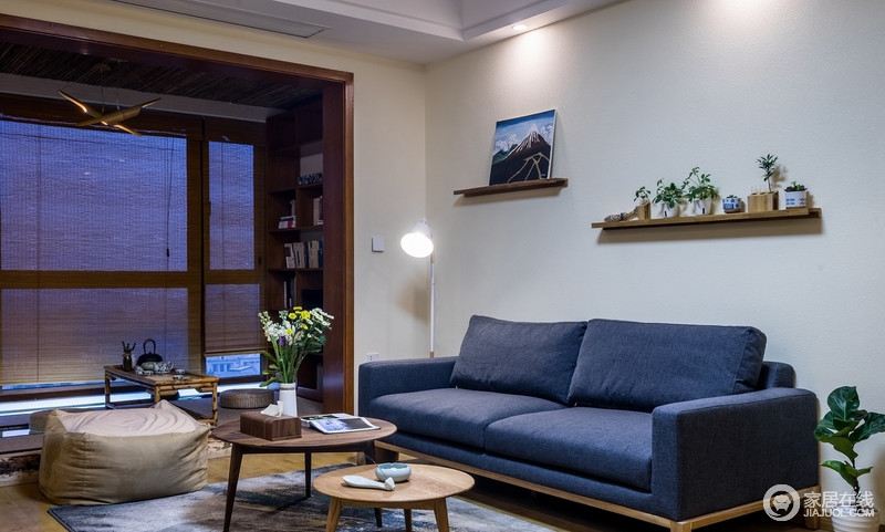 空间以日式的方式来构筑生活，实木收纳架、家具统一了生活的格调，藏蓝色沙发搭配绿植，为生活带来色彩与生机。