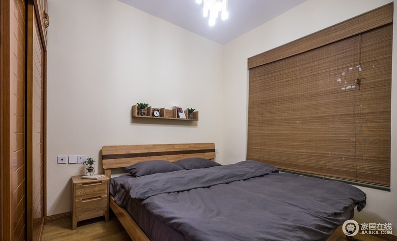 墙面空阔之中因为收纳小木架多了几分简单，而竹编的窗帘、深木纹色的壁柜搭配浅色的木地板，再搭配一盆绿叶植物，清新的自然气息无法阻挡，给你一个舒适的睡眠环境。